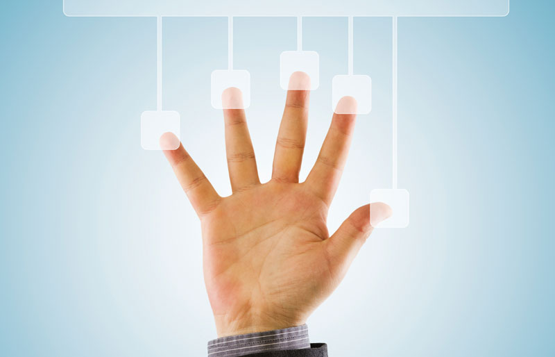 La main d’un homme d’affaires, dont les doigts écartés touchent cinq éléments graphiques, est collée contre un écran tactile transparent.