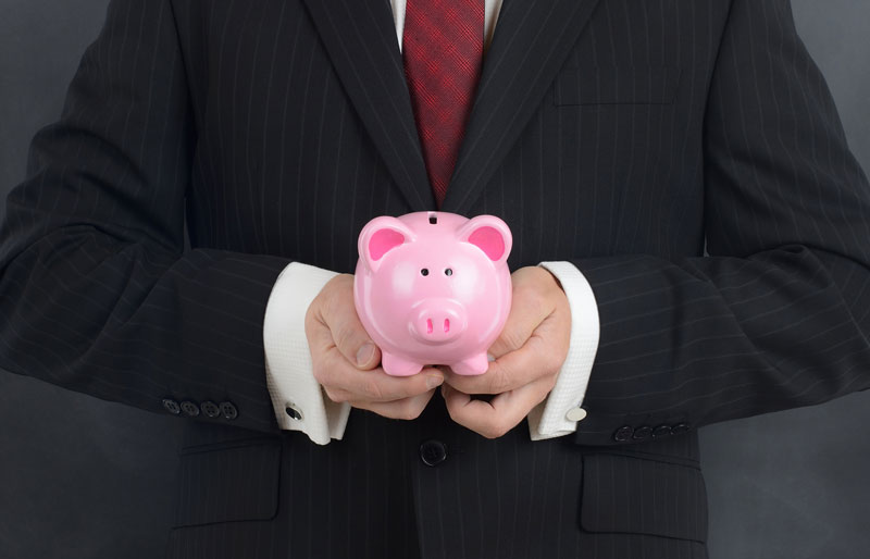 Business man holding piggy bank in hands