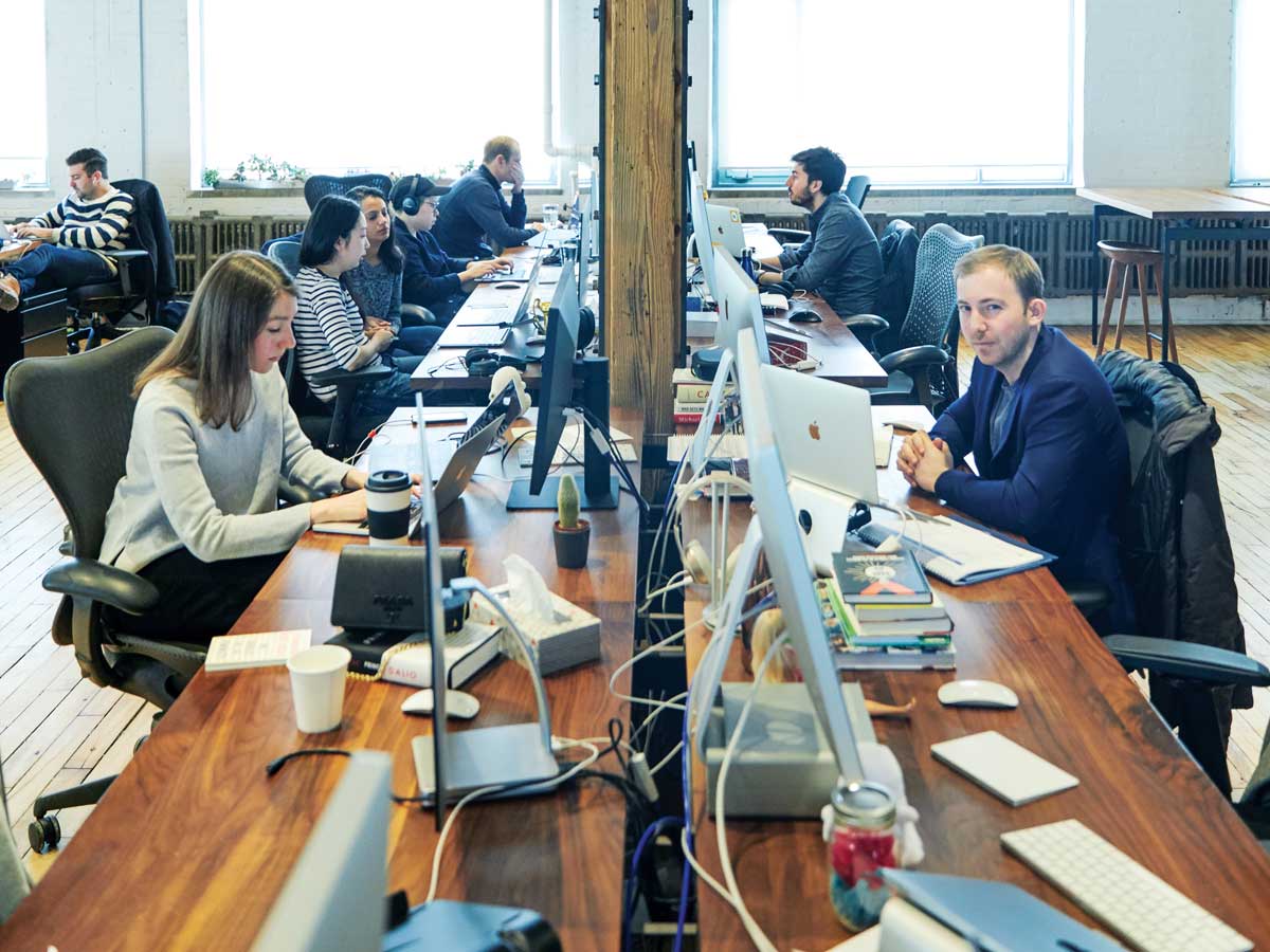 Michael Katchen (on right) looking inconspicuous at Wealthsimple headquarters, among the staff at their desks