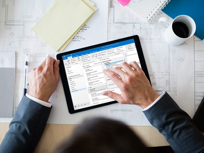  Vue aérienne de l'homme d'affaires en utilisant le programme Outlook sur sa tablette, à son bureau