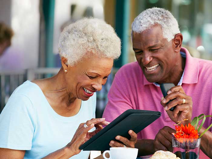 Senior couple using a tablet computer at a outdoor cafe