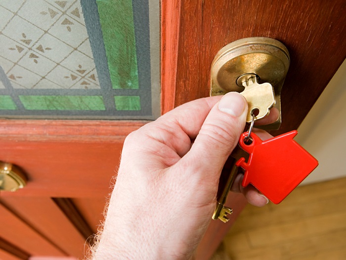 Buyer turning key in door lock