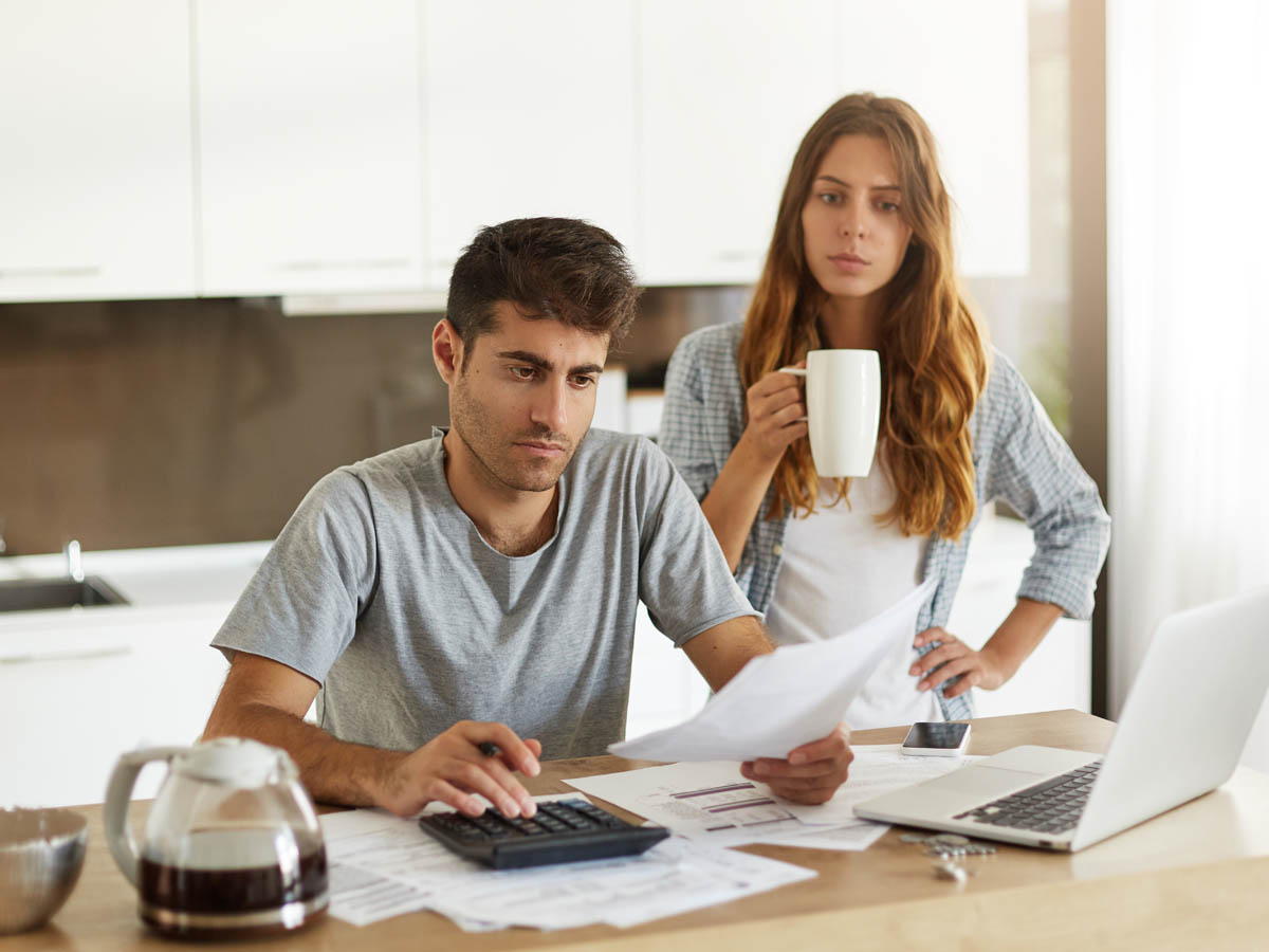 Young couple managing family budget in kitchen