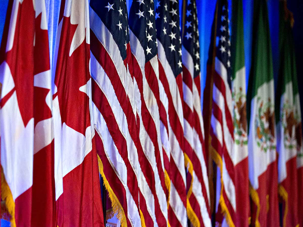 Une rangée de drapeaux des trois pays d'Amérique du Nord côte à côte lors des négociations commerciales avec l'ALENA