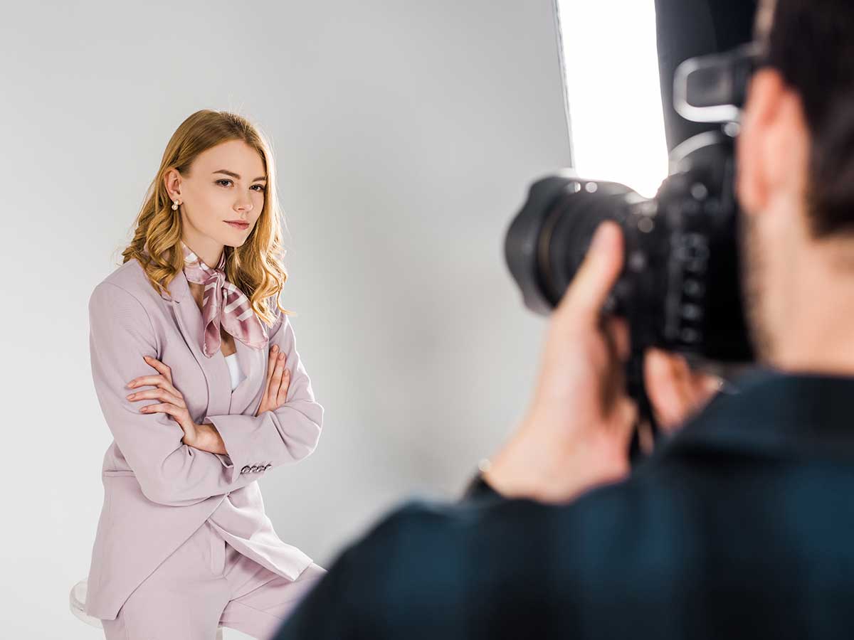 photographe photographiant une jeune femme d'affaires dans un studio de photographie