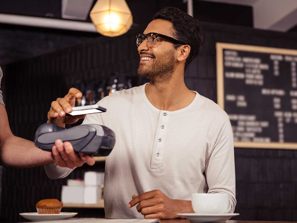 Homme utilisant un paiement mobile dans un café