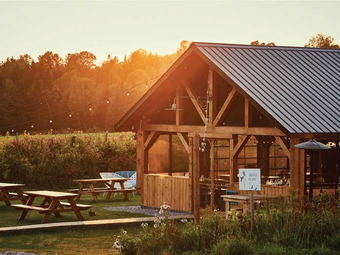 Farmhouse with picnic tables with a sunset