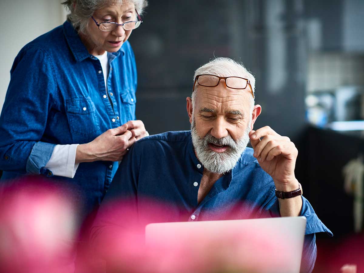 couple de personnes âgées à l'aide d'un ordinateur portable pour examiner leurs finances ensemble