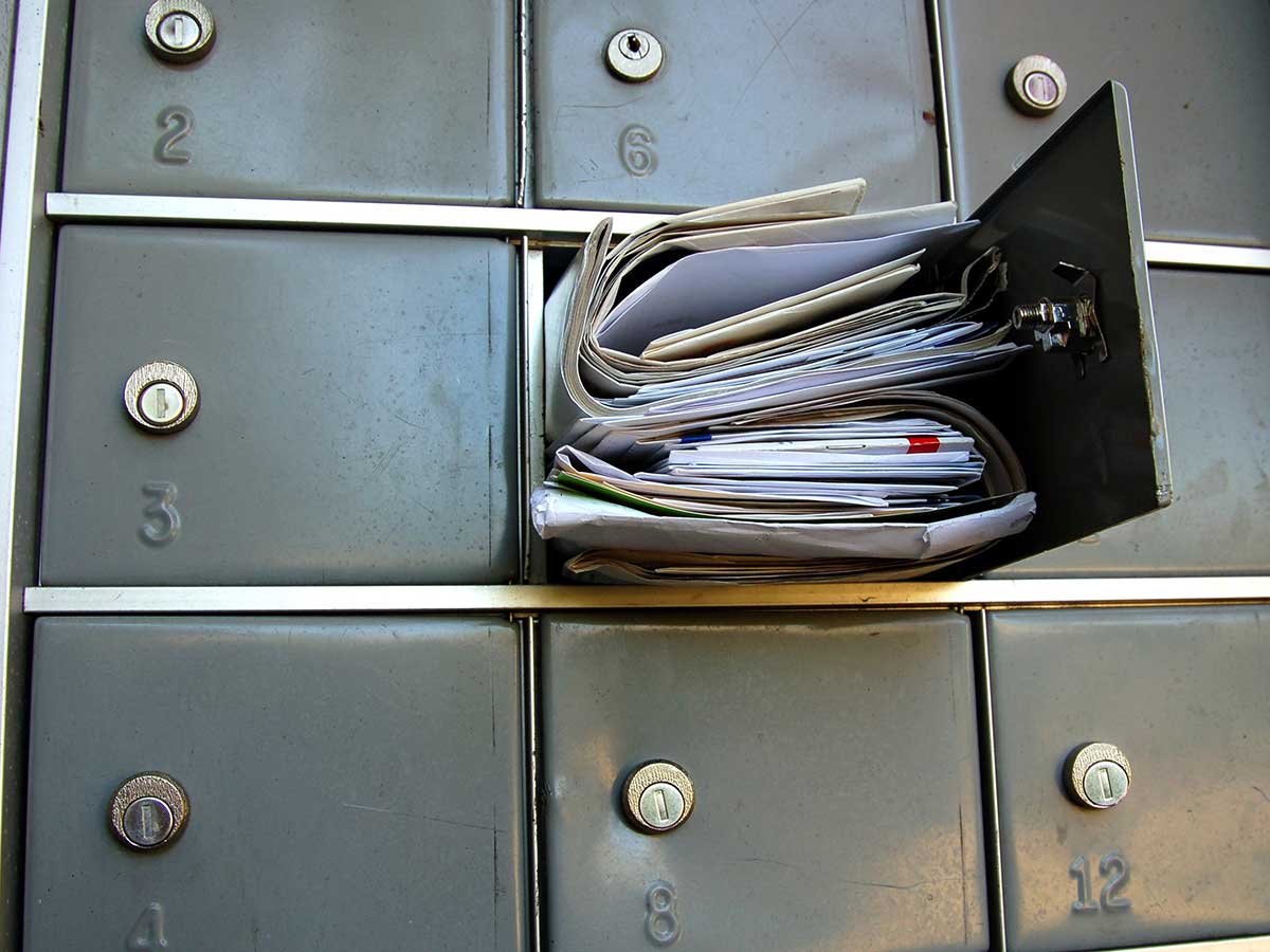 Boîte aux lettres débordante de courrier, factures, courrier indésirable et autres correspondances non désirées