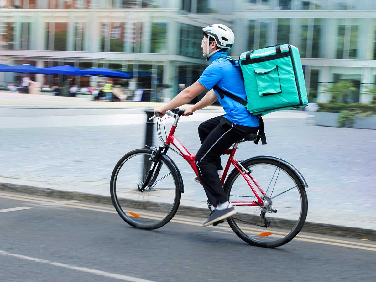 Courier on bicycle delivering food In city