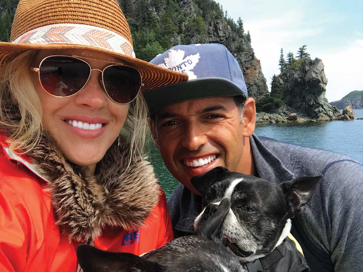 Comedian Shaun Majumder and wife Shelby Fenner with their dogs by the waters of Newfoundland