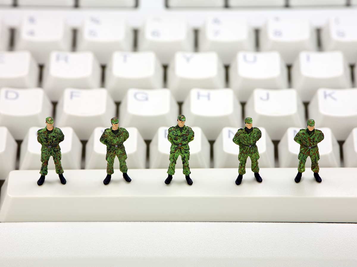 Miniature toy army soldiers standing on a computer keyboard guarding against viruses, spyware and identity thieves