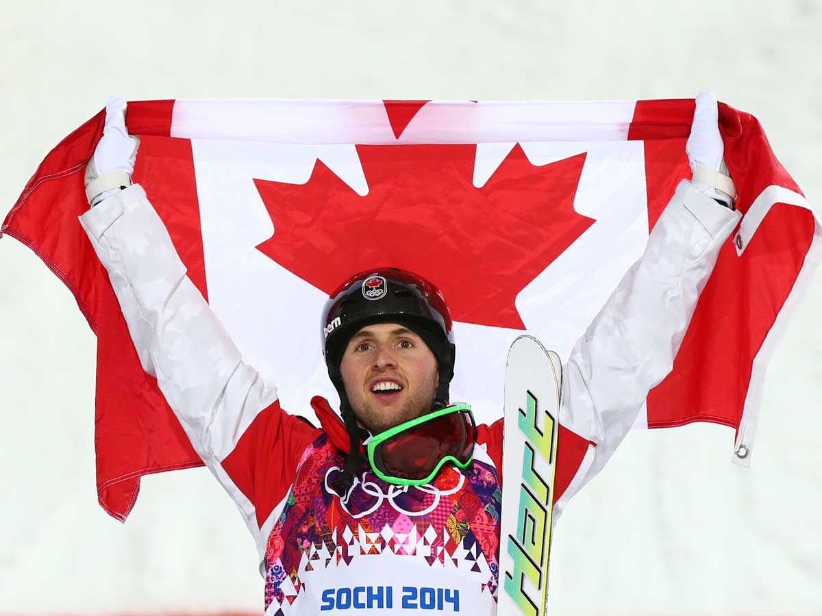 Gold medalist Alex Bilodeau of Canada celebrates during the flower ceremony for the Men's Moguls Finals on day three of the Sochi 2014 Winter Olympics