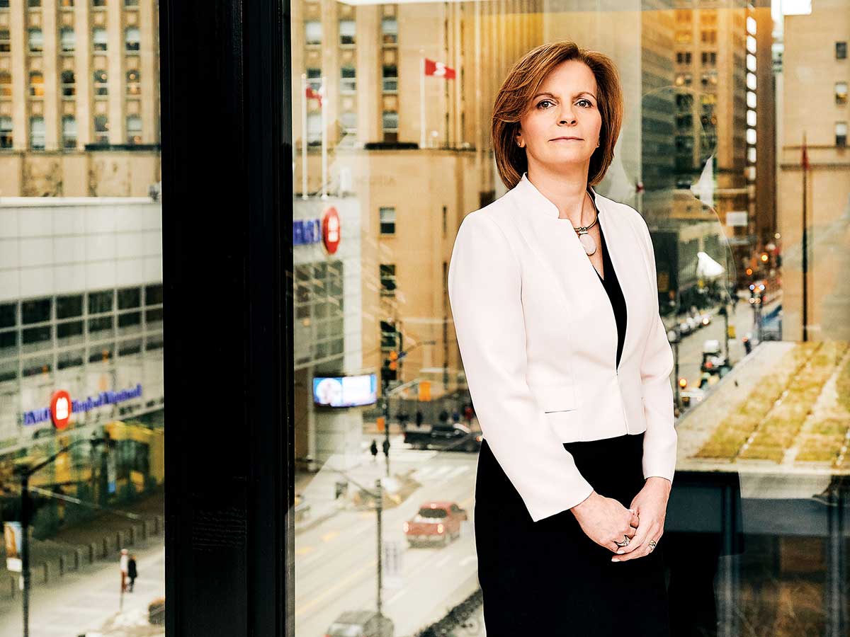 portrait of Beth Wilson standing in window of the Dentons Canada office in Toronto’s Financial District