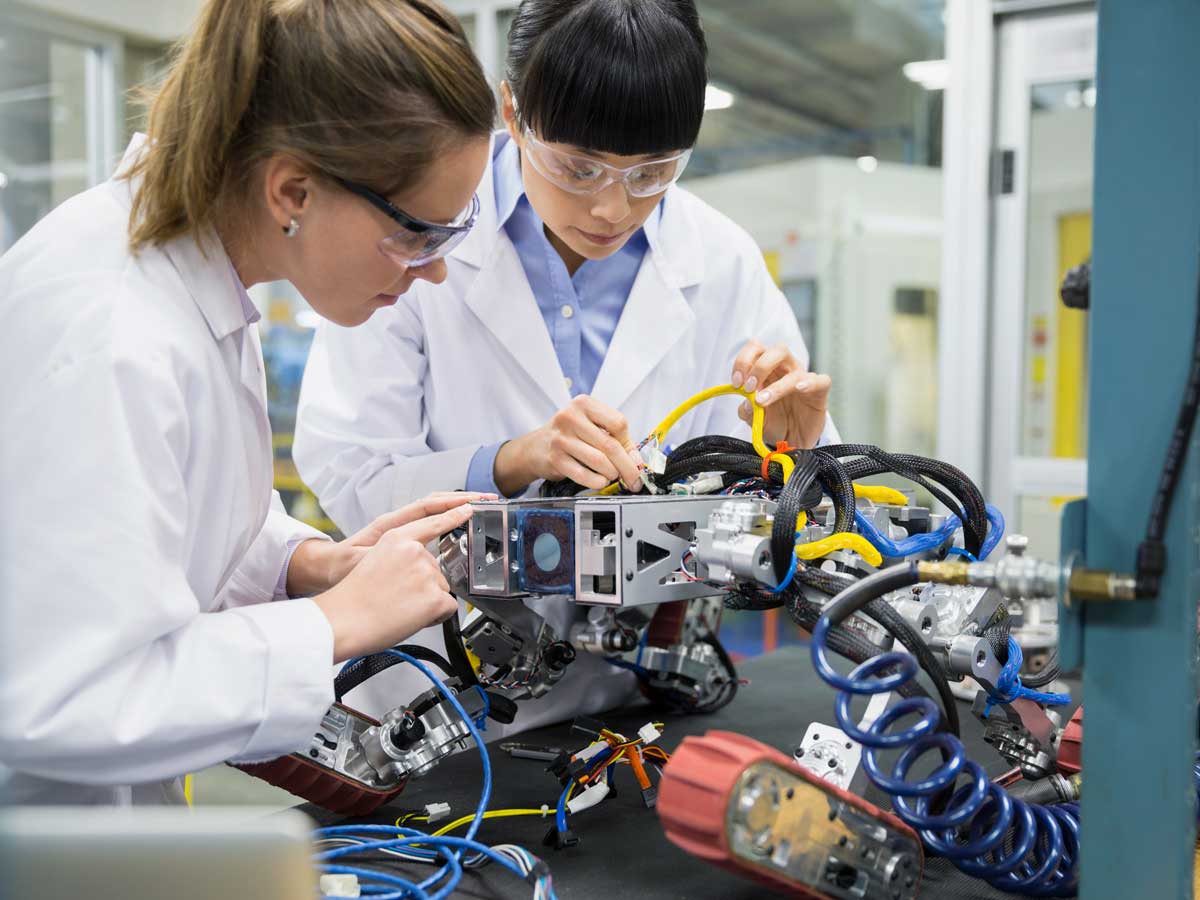 Engineers assembling robotics in factory