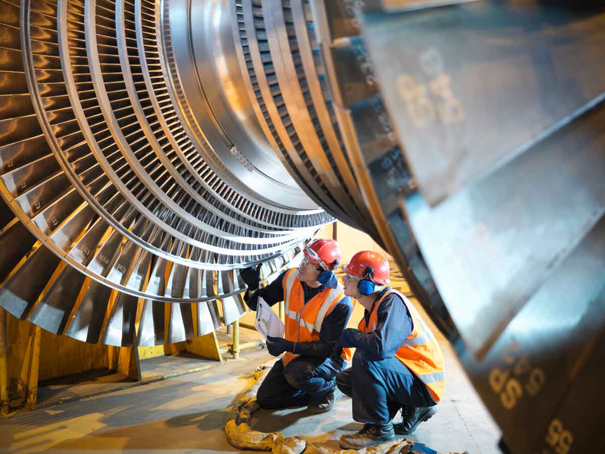 Workers inspect turbine in power station
