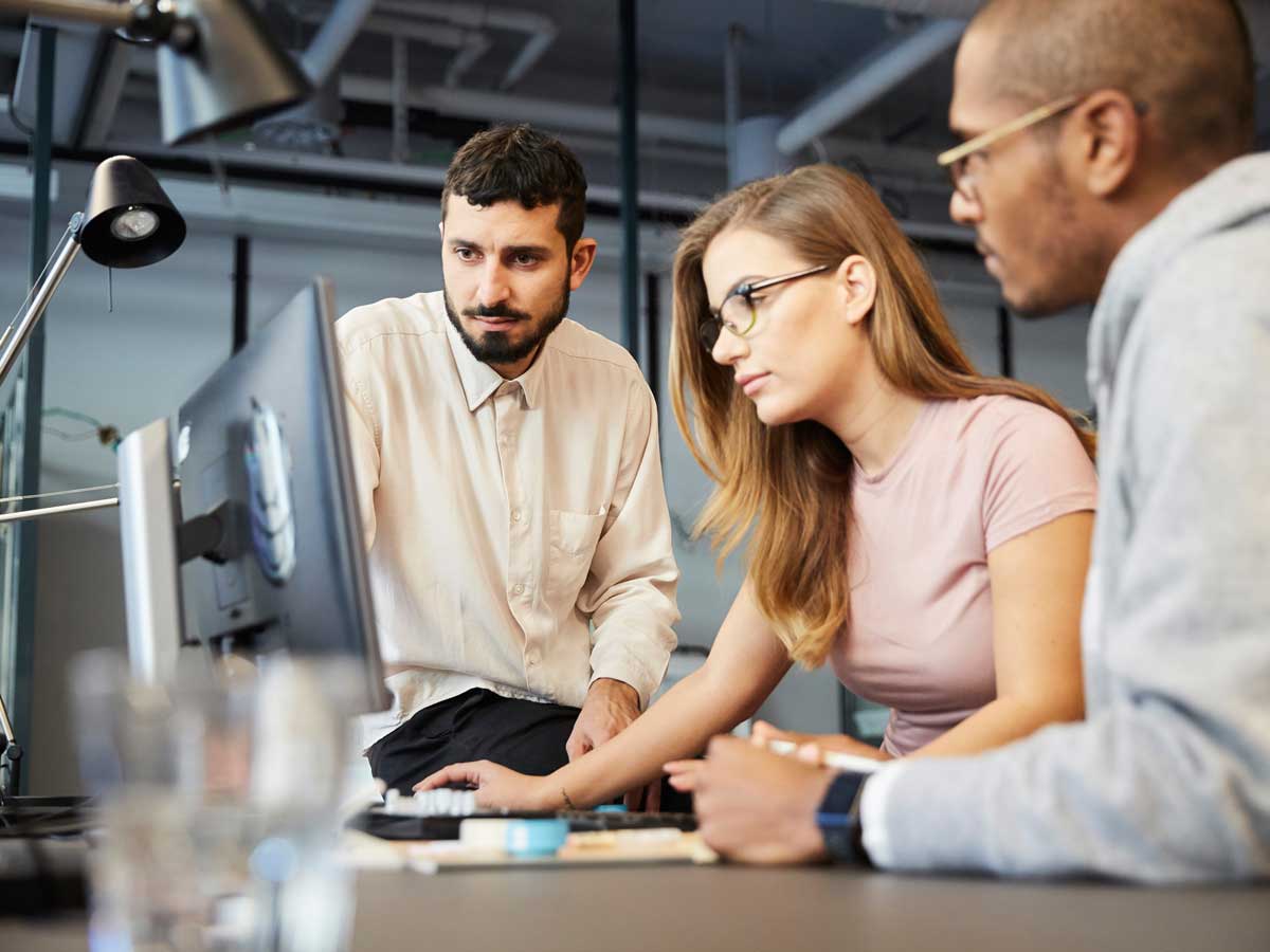 Créatifs entrepreneurs masculins et féminins à la recherche d'un écran d'ordinateur lors d'une réunion au bureau