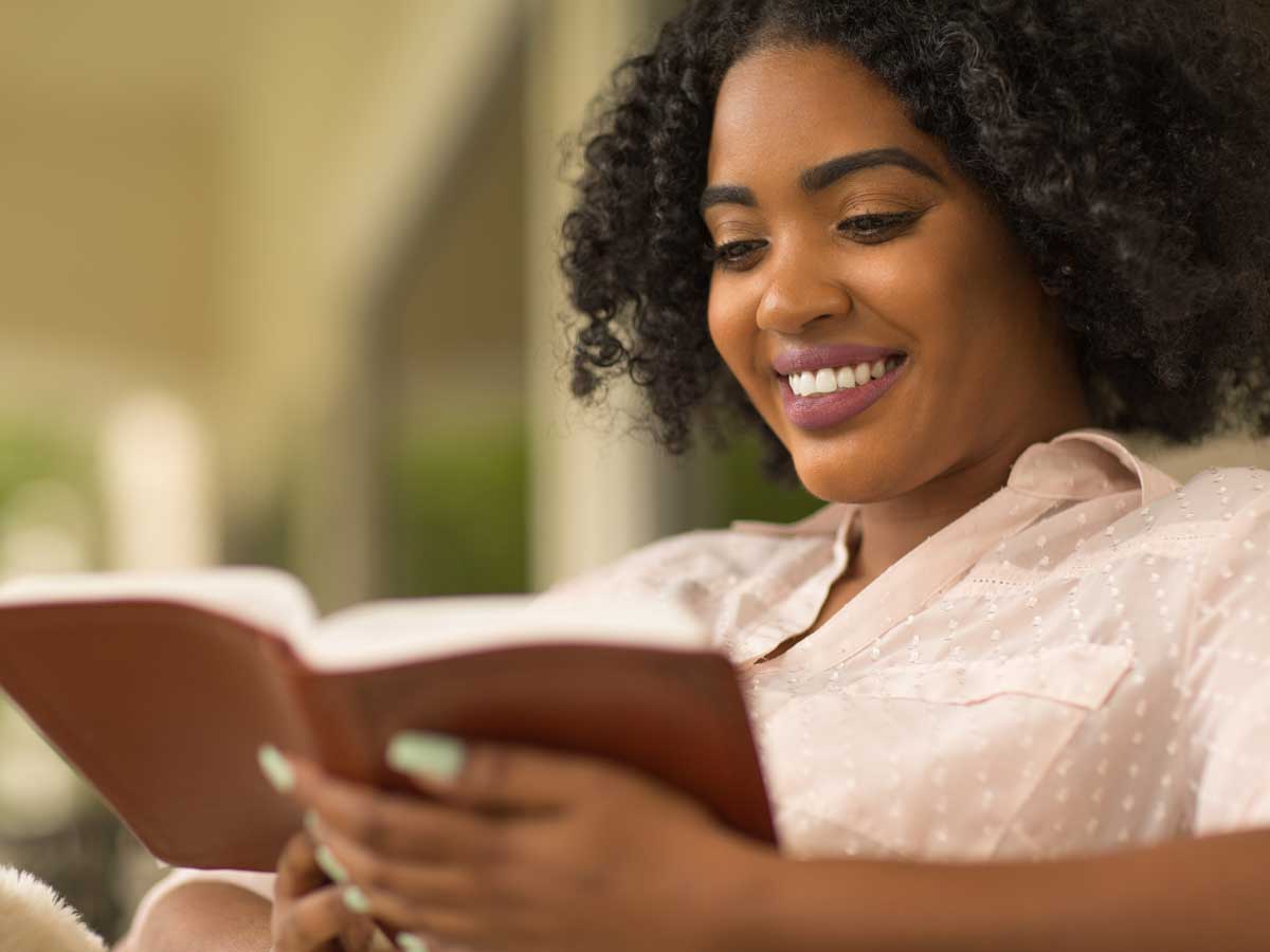 Woman smiling while reading a book