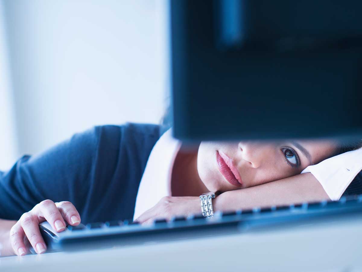 Businesswoman looking tired in front of computer 
