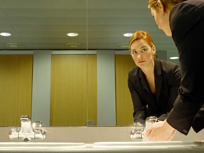 Young businesswoman in bathroom, washing hands
