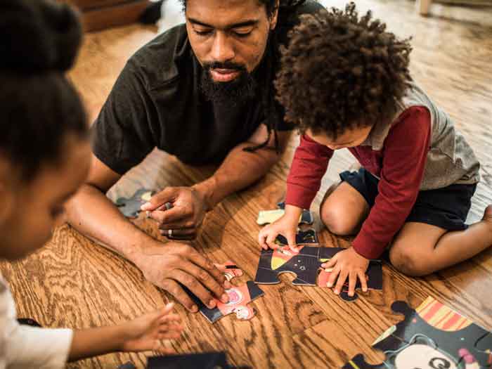 Père faisant un puzzle avec ses enfants