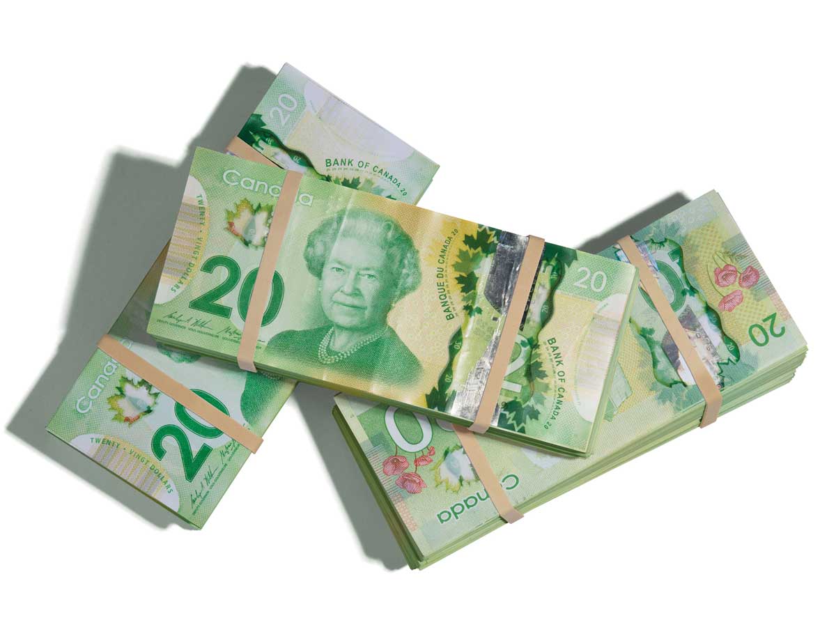 Three wads of Canadian $20 bills secured with elastic bands