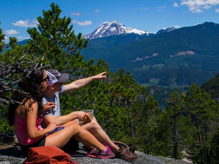 Couple sitting on top of mountain looking at view