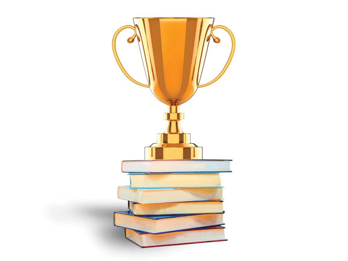 Image of gold trophy on top of stack of books