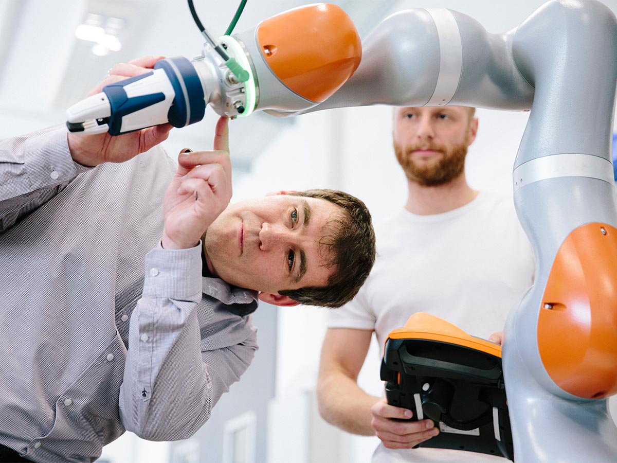  Two engineers work on a robotic arm
