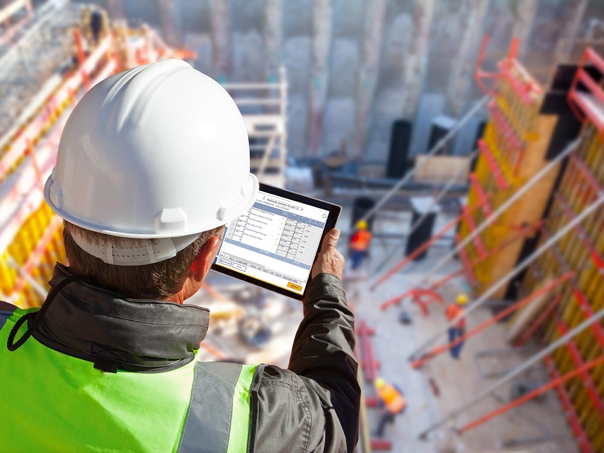 Worker at a construction site using a computer tablet