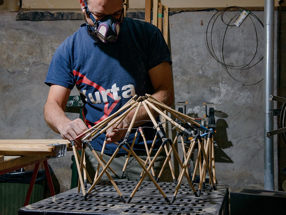 Man building model wooden yurt frame