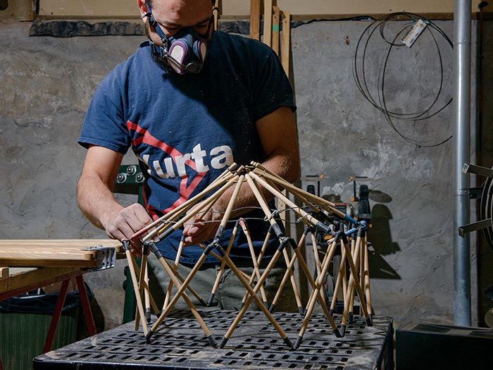 Man building model wooden yurt frame