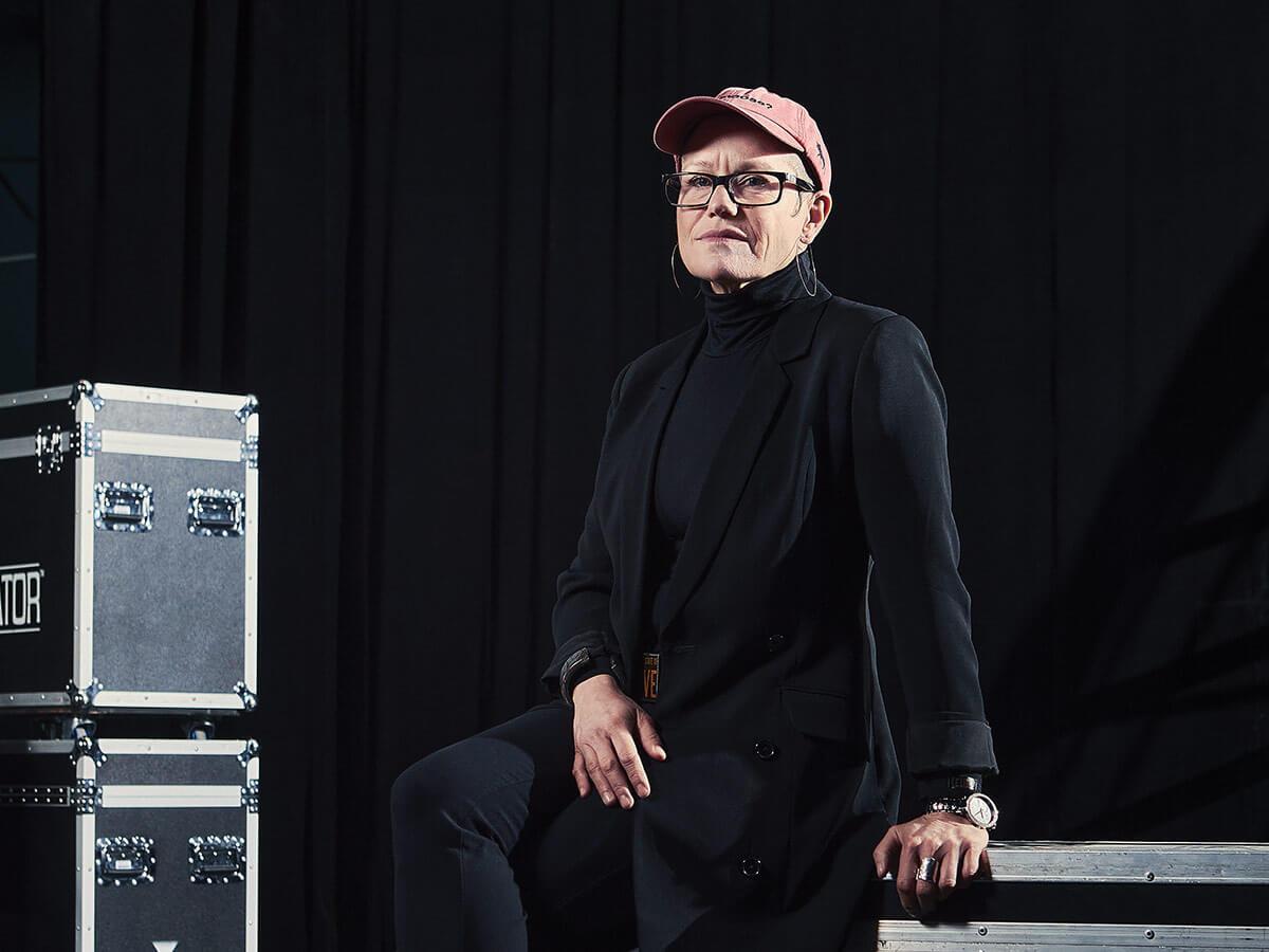Erin Benjamin, présidente et directrice générale de la Canadian Live Music Association, assise sur une caisse de route audio-vidéo sur une scène.