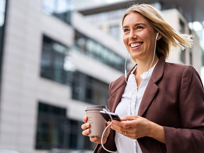 Businesswoman with headphones in city on the go
