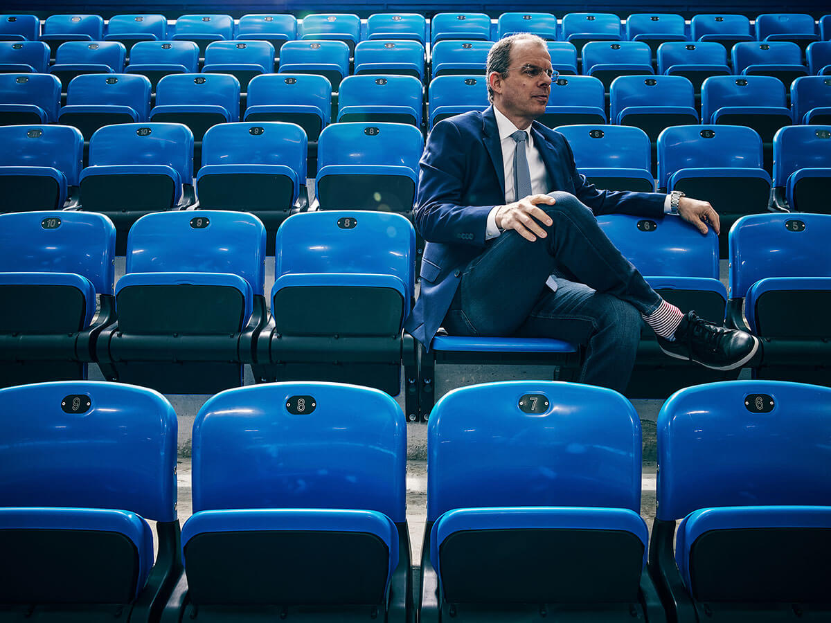 Portrait of Joe Resnick on the seats of a sports arena