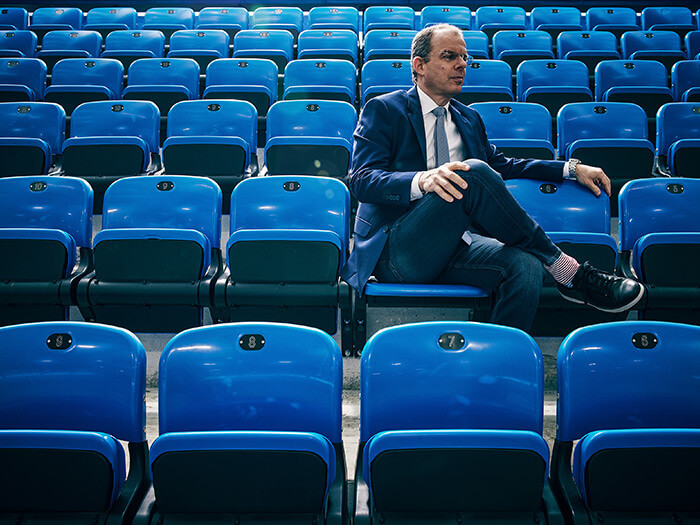 Portrait of Joe Resnick on the seats of a sports arena
