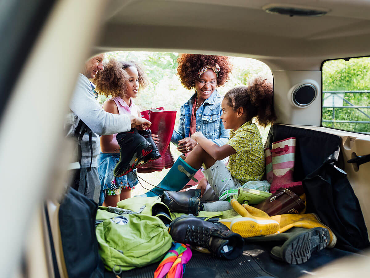 Mixed-race family unpacking car