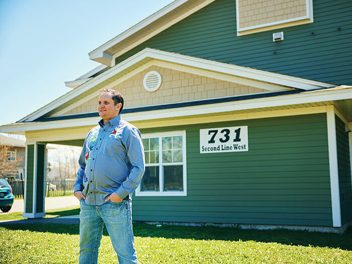CPA Justin Marchand stands in the backyard of a home.
