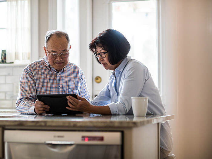 Couple de seniors utilisant une tablette dans la cuisine