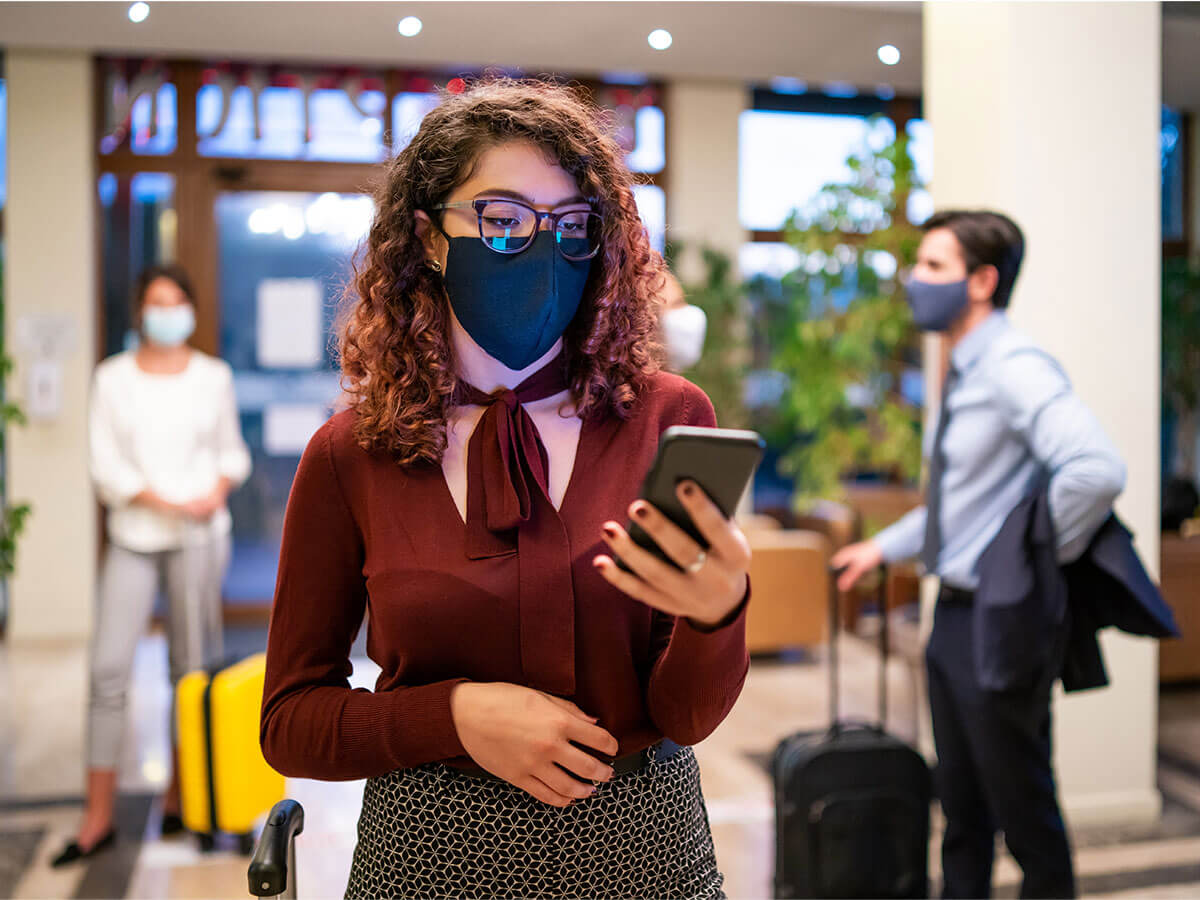 Hotel guests wearing protective face mask and keeping social distance during COVID-19