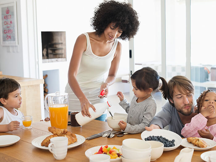 Family sitting at a breakfast table in a bright kitchen