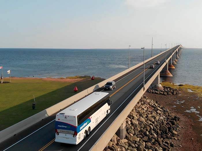 a bus is shown driving on a two lane bridge over a large body of water