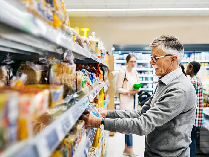 Homme âgé choisissant du pain au supermarché