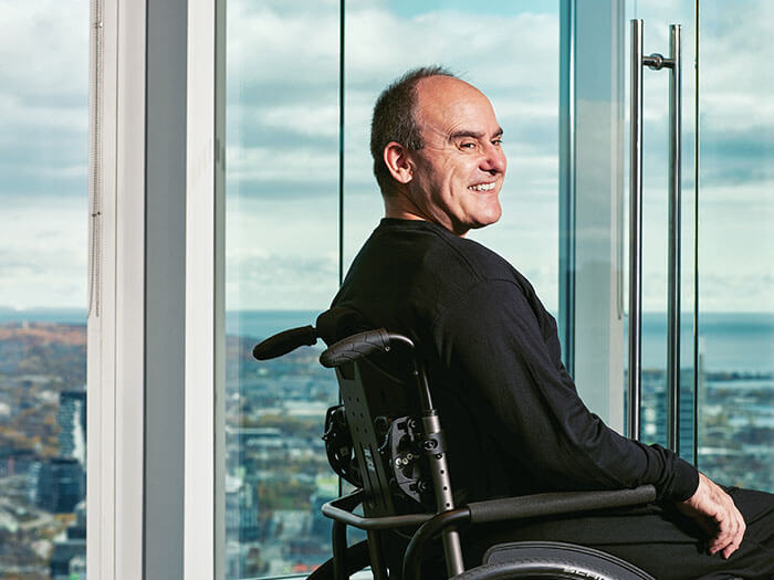 A man in a wheelchair sits next to a window