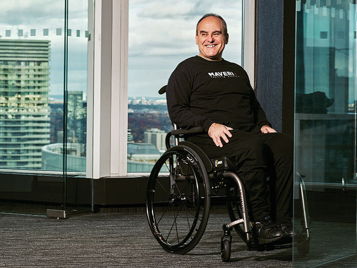 Un homme en fauteuil roulant est photographié près d'une fenêtre.