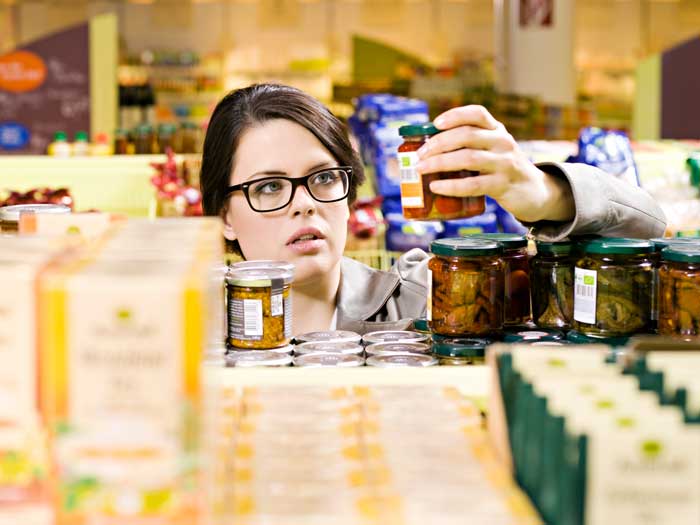 A shopper looks at jars of food in a grocery store