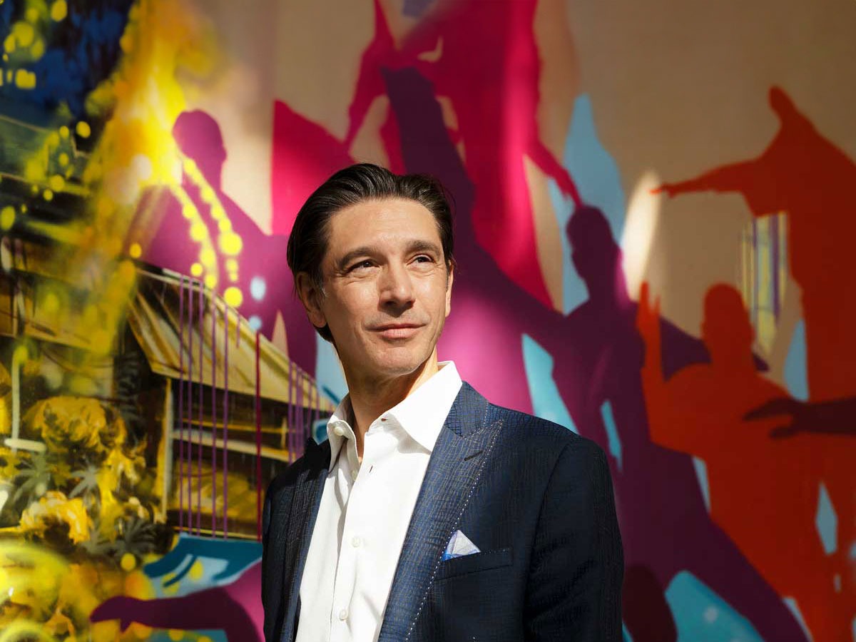 Businessman Stéphane Lefebvre stands in front of a colourful wall
