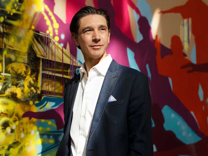 Businessman Stéphane Lefebvre stands in front of a colourful wall