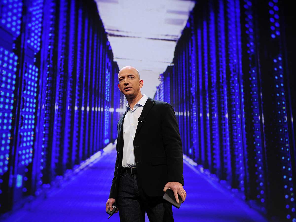 Jeff Bezos poses in a blue computer server room