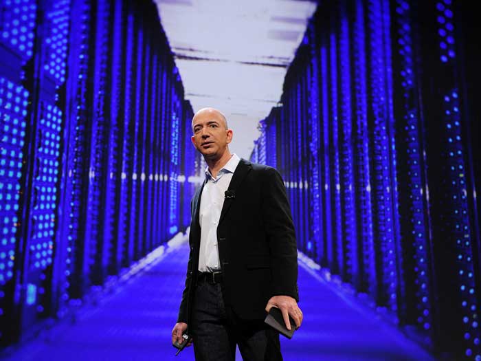 Jeff Bezos pose dans une salle de serveurs informatiques bleue